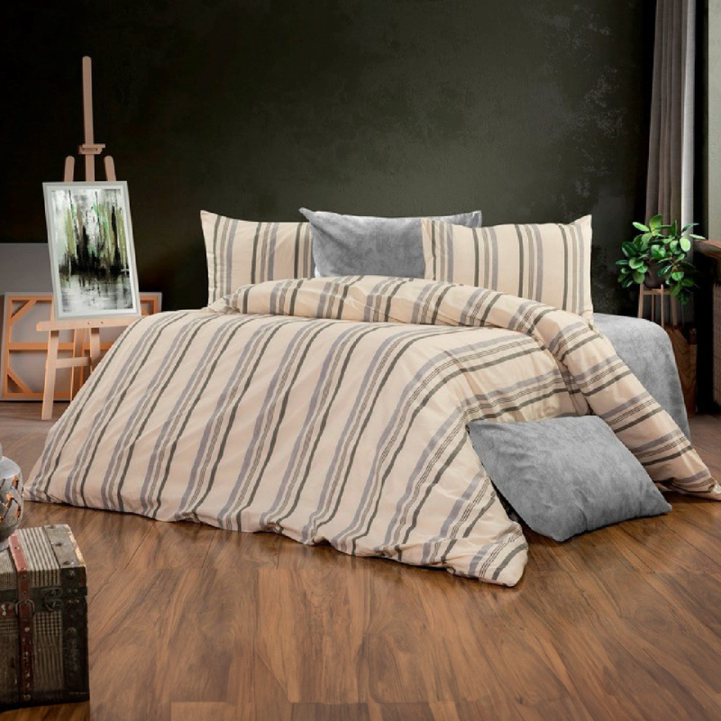 Striped beige and grey cotton bedding set with duvet cover and pillows on wooden floor