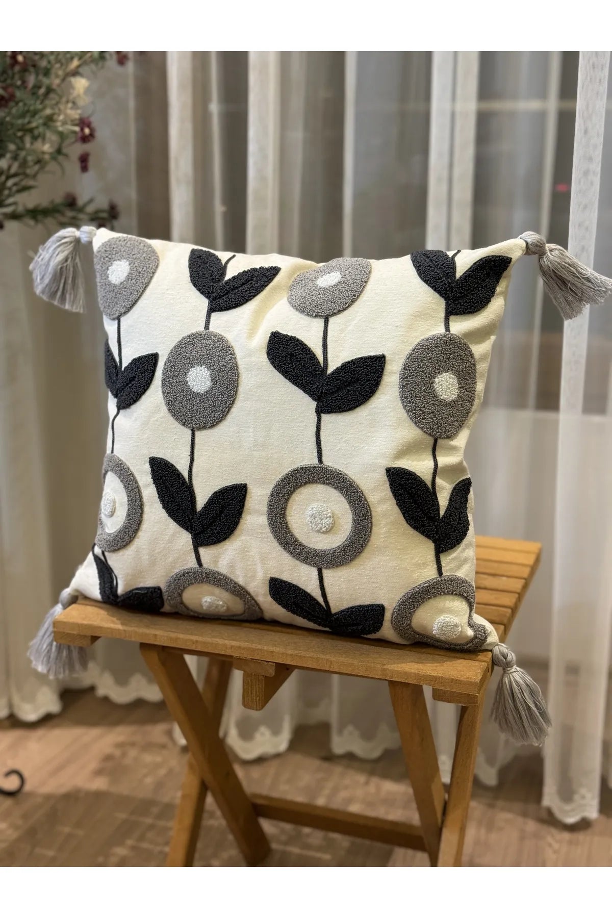 Nordic Bloom cushion cover with navy and grey floral embroidery and tassels