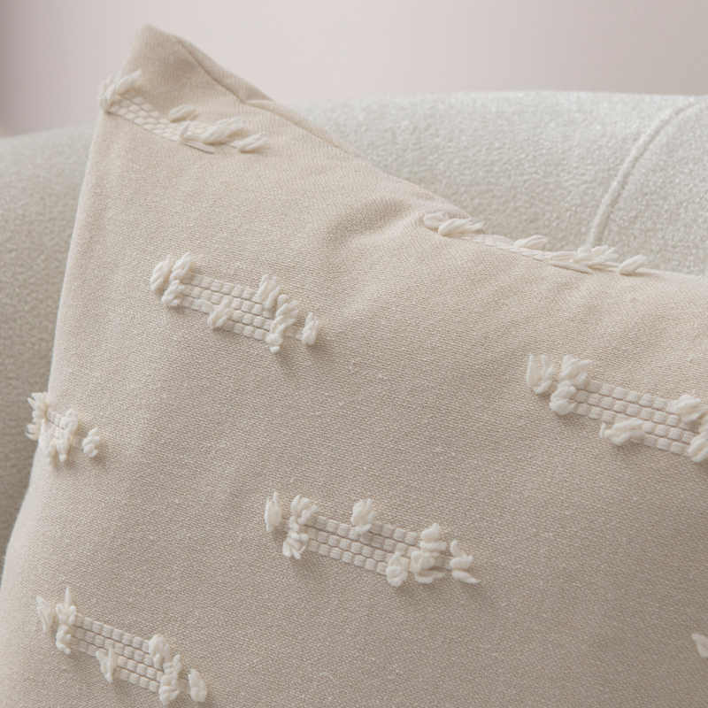 Beige textured woven throw pillow on light sofa – decorative cushion with woven tufted details