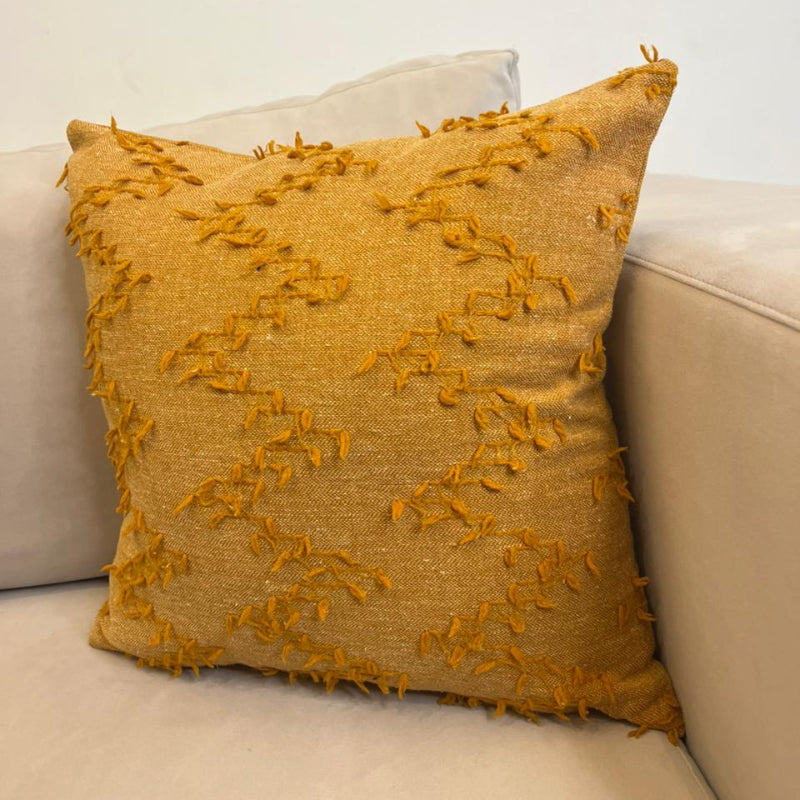 Burnt orange textured fringe decorative cushion cover with woven fabric on beige sofa
