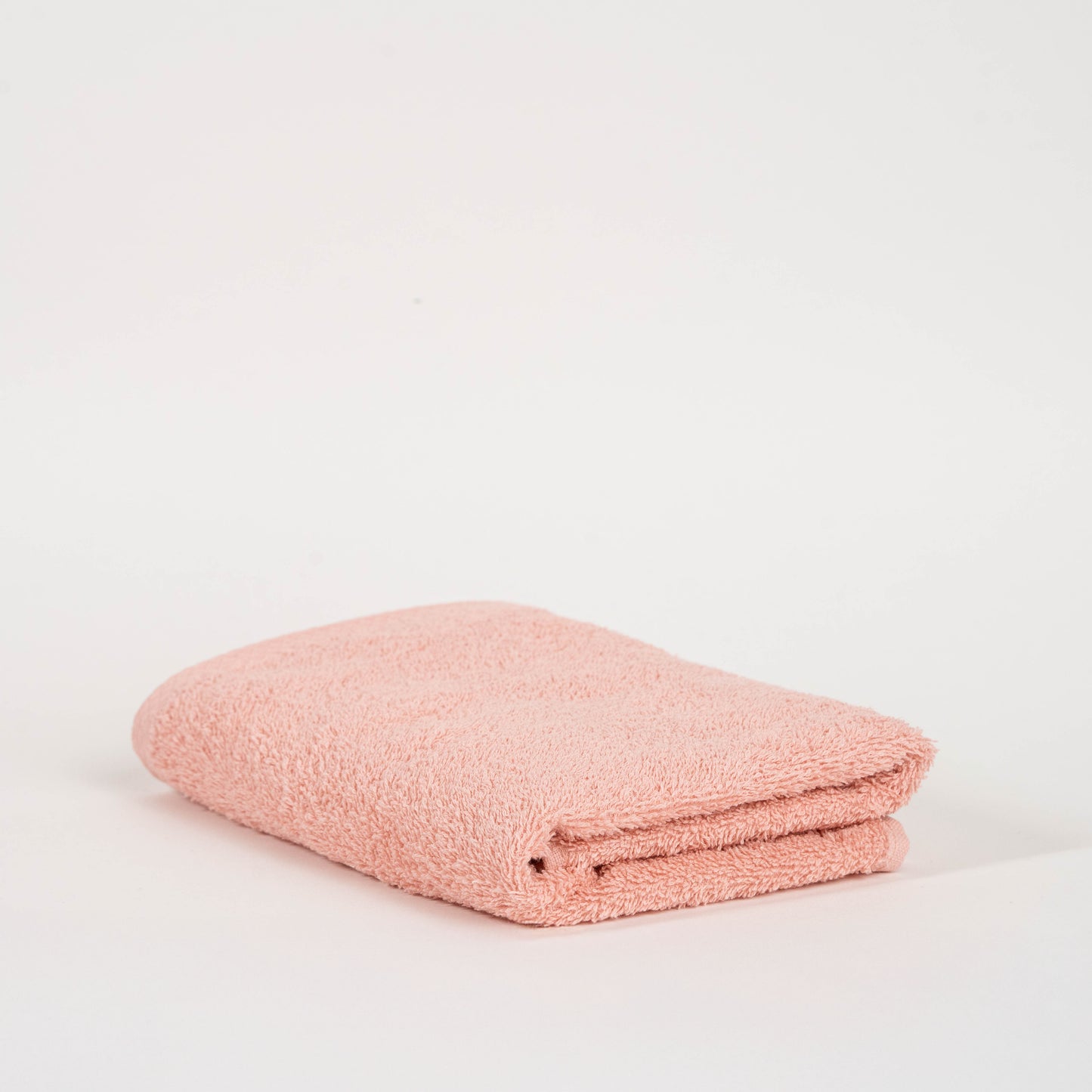 Absorbent blush pink cotton towel folded neatly.