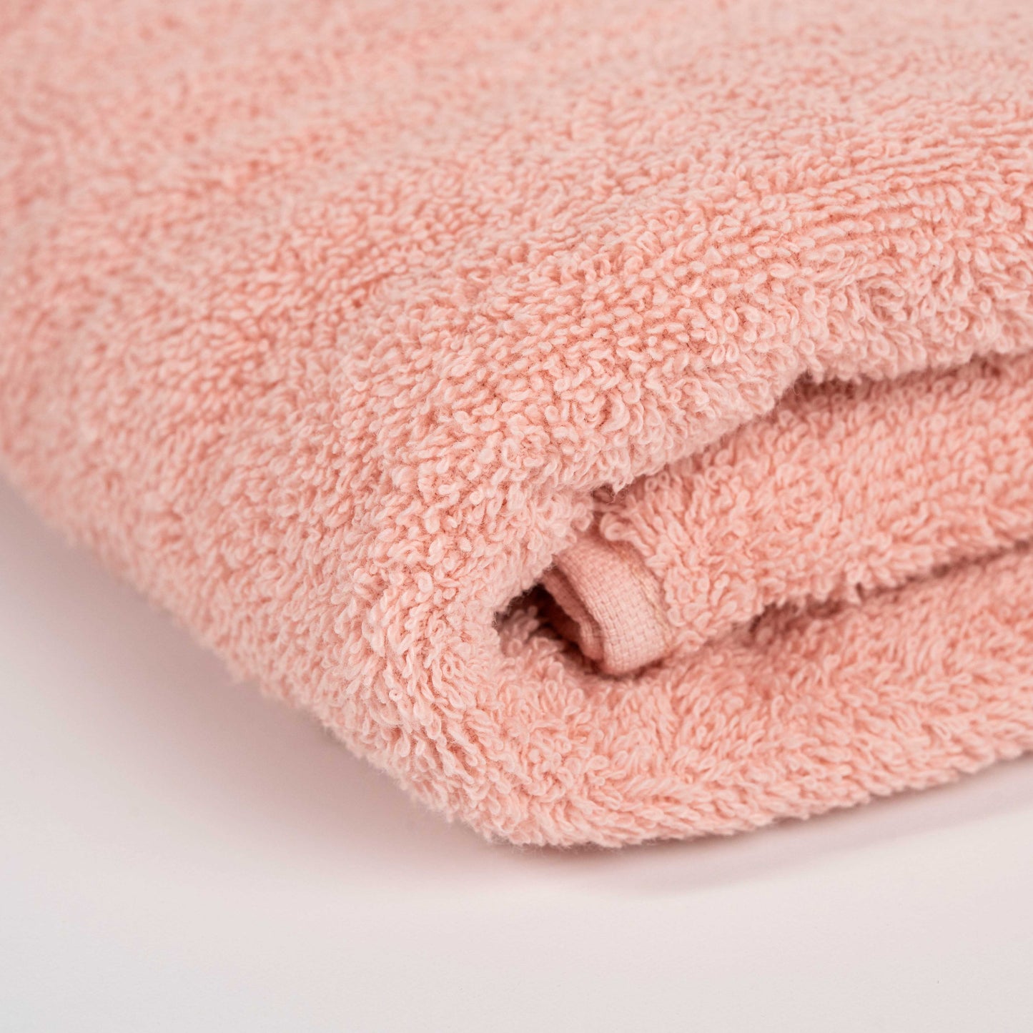 Absorbent blush pink cotton towel folded neatly.
