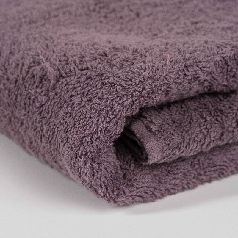 Absorbent plum purple cotton towel folded neatly.