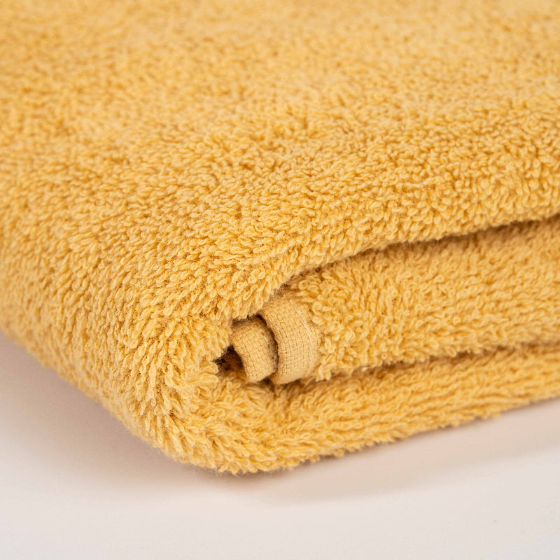 Absorbent honey yellow cotton towel folded neatly.