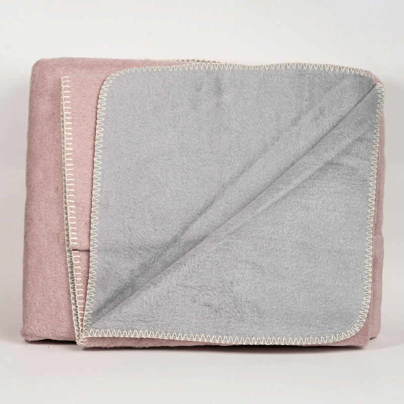 Double-face fleece blanket in pink and grey draped on chair