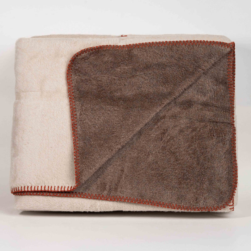 Double-face fleece blanket in pink and grey draped on chair