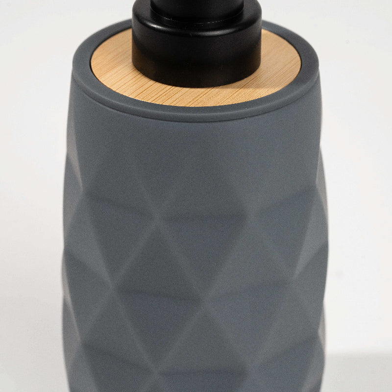 Set of four geometric soap dispensers in gray, white, beige, and black with bamboo detail
