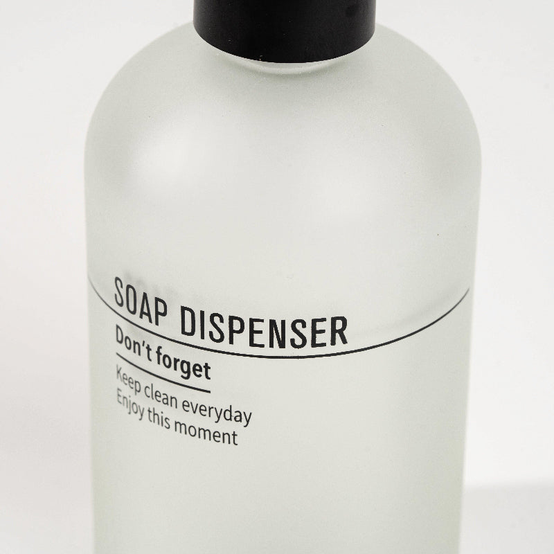 Frosted glass soap dispenser with black pump and modern text design