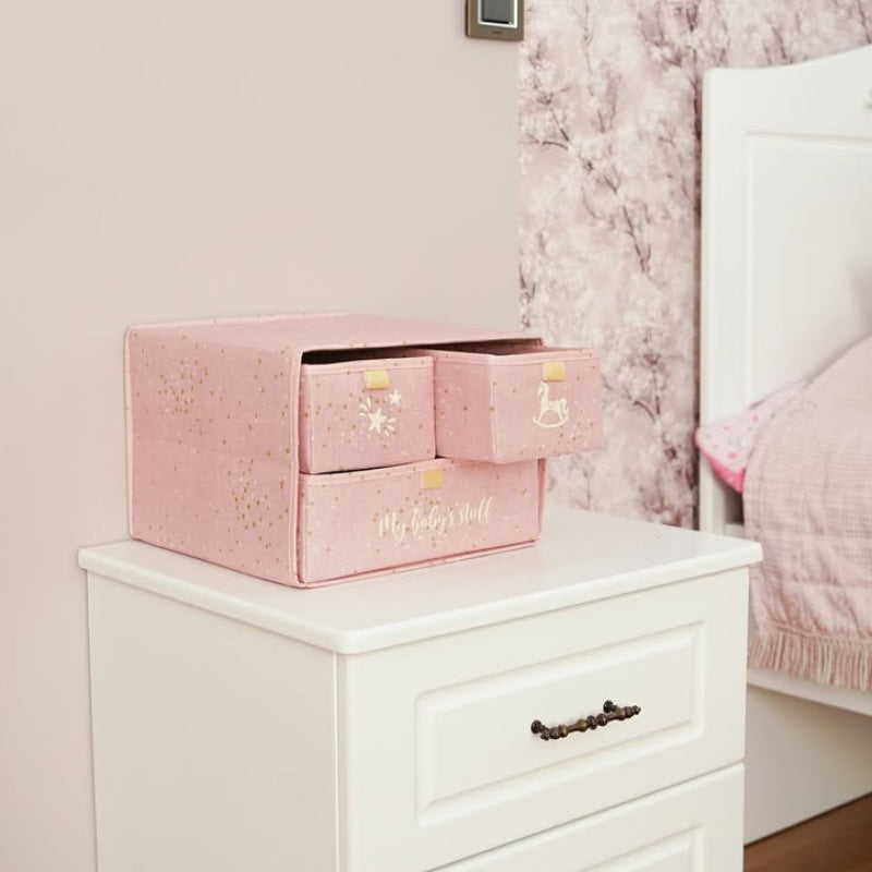 “Pink fabric storage organizer with three drawers for baby clothes and toys”
“Nursery drawer organizer in pink fabric with golden star design”
“Compact pink storage box with fabric handles for kids’ room”
“Baby essentials organizer with three pull-out fabric drawers”
“Pink fabric chest for baby clothes, toys, and accessories storage”
