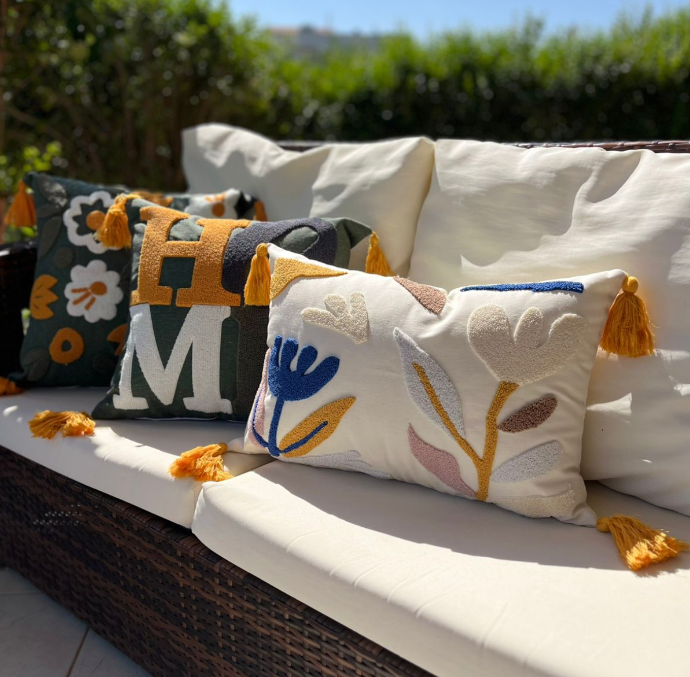Olive Comfort Collection square cushion cover embroidered with the word HOME in mustard, grey, white, and olive green, finished with mustard tassels – 43x43 cm decorative pillow