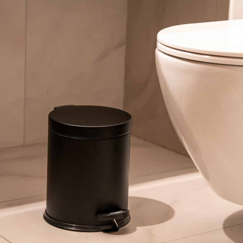 Matte black pedal bin next to toilet in modern bathroom