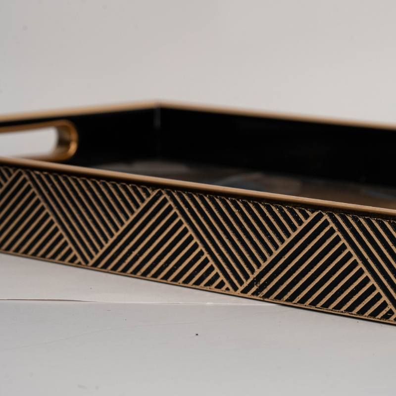 Rectangular black and gold tray with abstract line design
Decorative serving tray with golden handles and modern pattern
Black and gold rectangular tray styled for coffee table décor
Luxury decorative tray with abstract artistic design