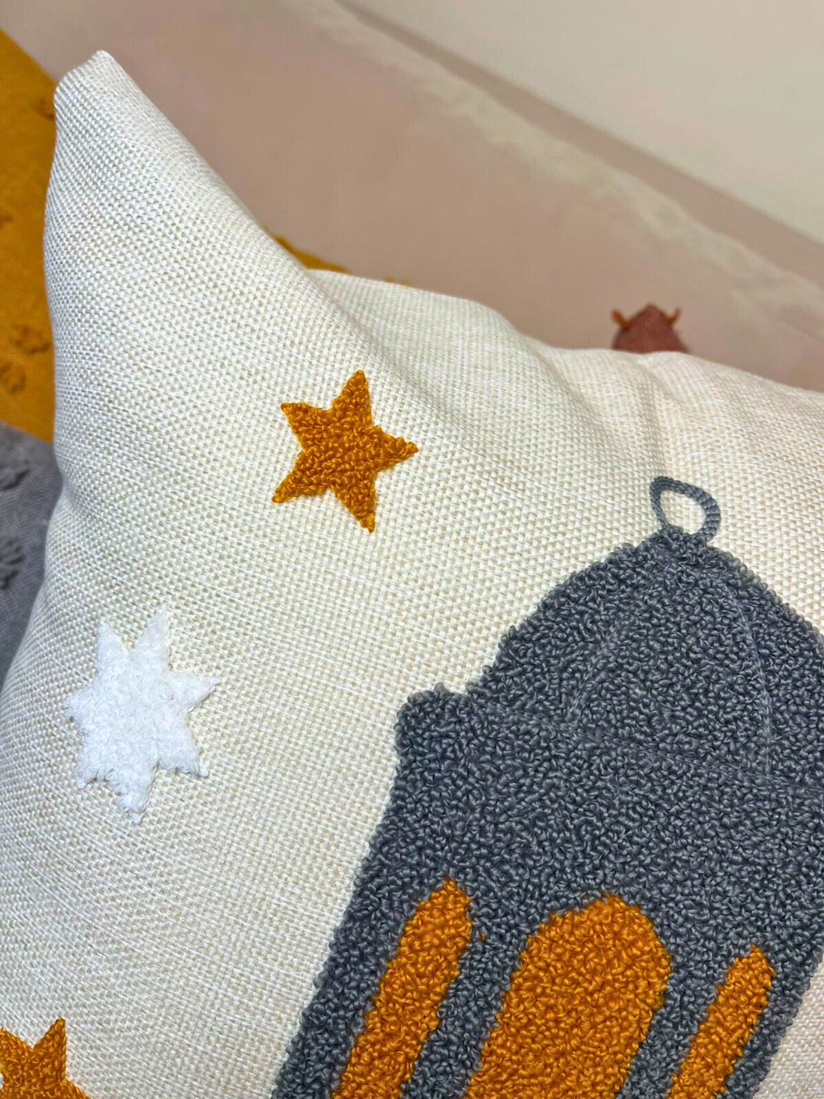 Square cushion cover with embroidered Ramadan lantern and Arabic Ramadan Kareem text on sofa