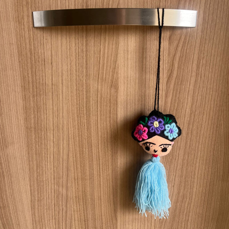 Handmade Frida Kahlo inspired felt ornament with embroidered flowers and light blue tassel hanging decor