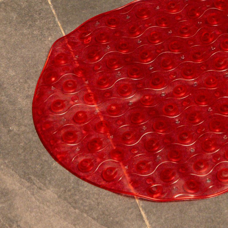 Red anti-slip capsule rubber shower mat on gray tiled bathroom floor