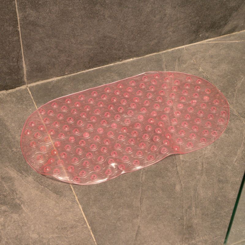 Soft pink anti-slip capsule rubber shower mat on gray tiled bathroom floor