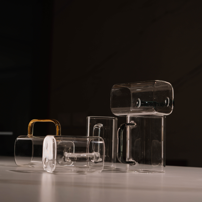 “Clear glass mug with collorful handle – modern minimalist design for coffee and tea