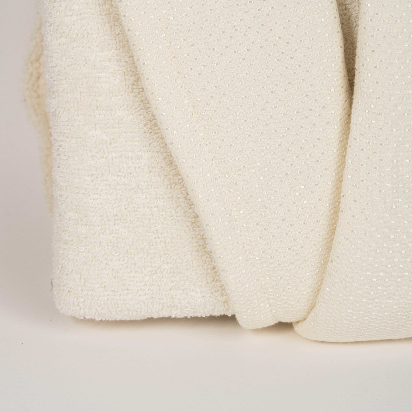 Unisex cotton terry bathrobe with shawl collar and waist belt, worn by woman near window in natural light