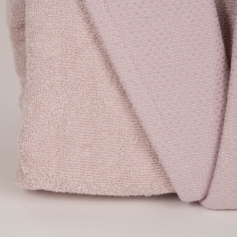 Unisex cotton terry bathrobe with shawl collar and waist belt, worn by woman near window in natural light