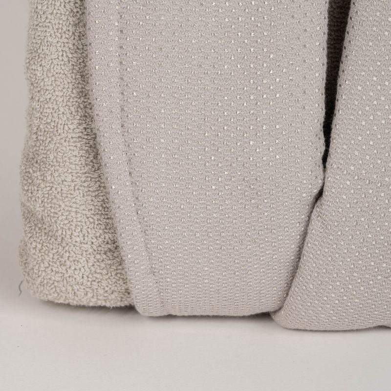 Unisex cotton terry bathrobe with shawl collar and waist belt, worn by woman near window in natural light