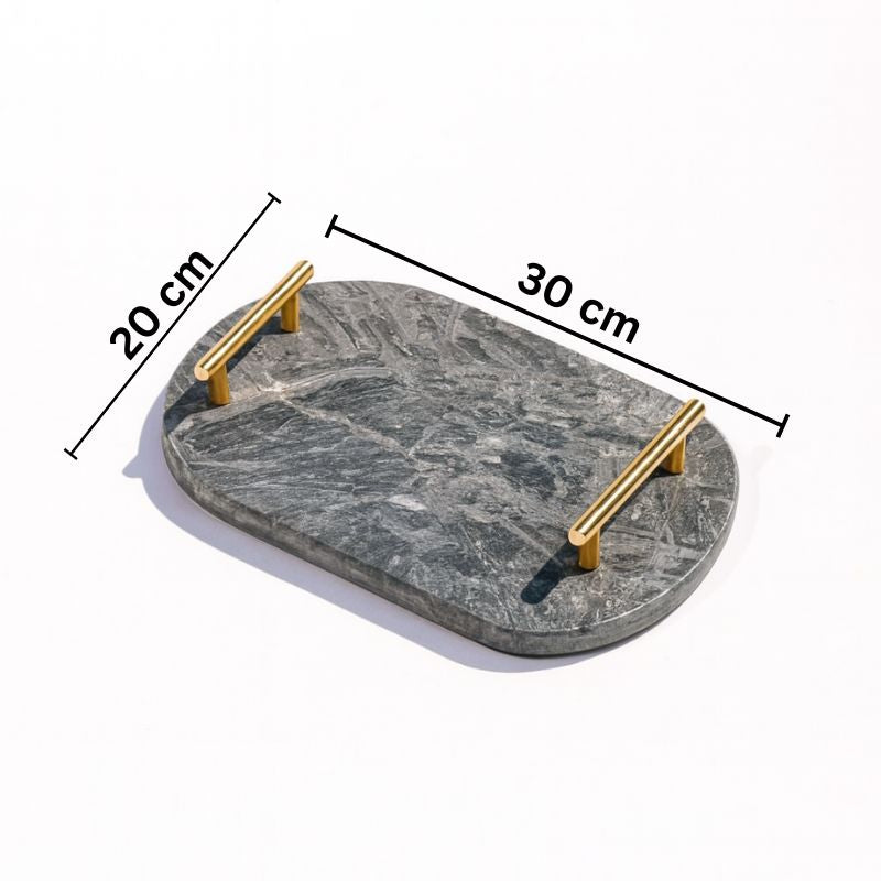 dark grey oval capsule-shaped marble tray with brass handles placed by the pool