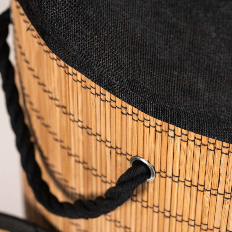 Round bamboo laundry basket with lid and black fabric lining.
