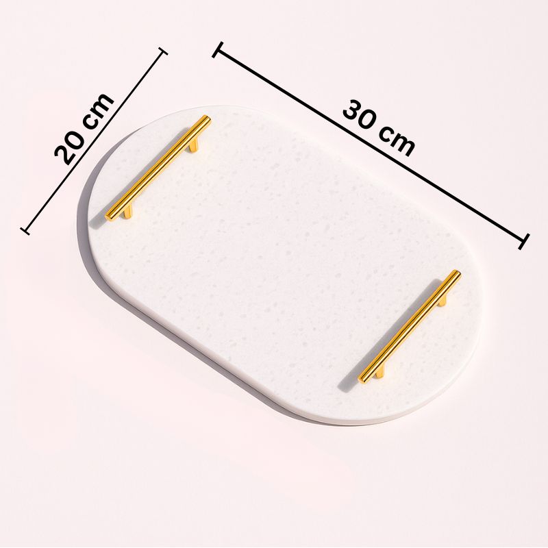 White oval capsule-shaped marble tray with brass handles placed by the pool