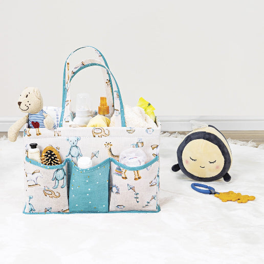 Portable baby diaper caddy organizer with compartments, filled with bottles, wipes, diapers, and teddy bear