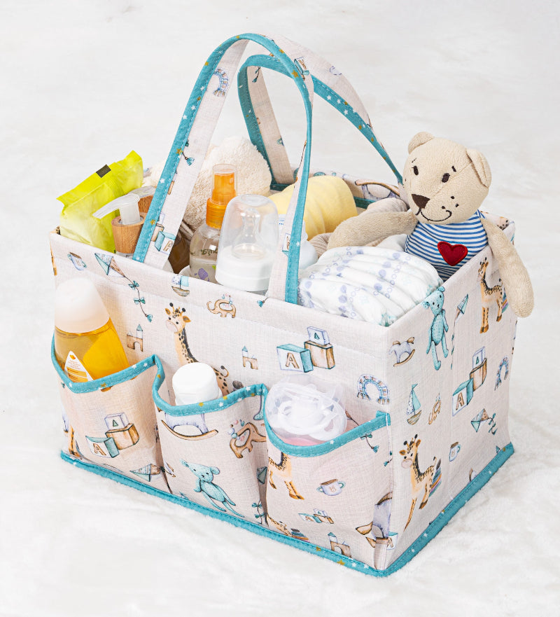 Portable baby diaper caddy organizer with compartments, filled with bottles, wipes, diapers, and teddy bear