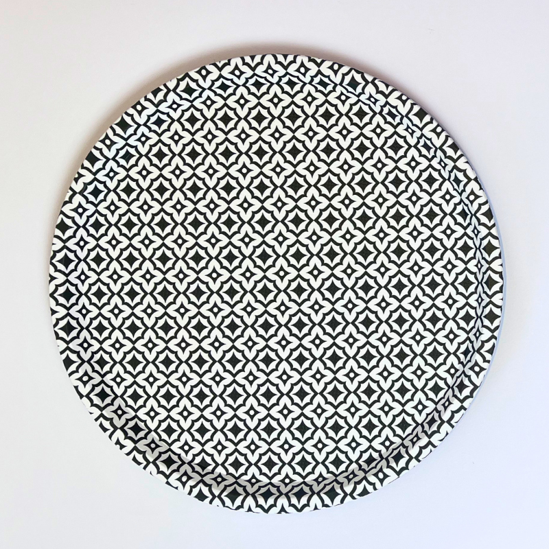 Round ceramic plate with black geometric pattern on a white background