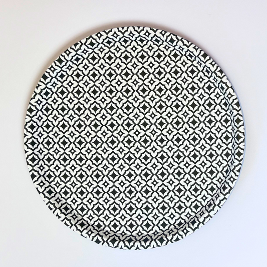 Round ceramic plate with black geometric pattern on a white background