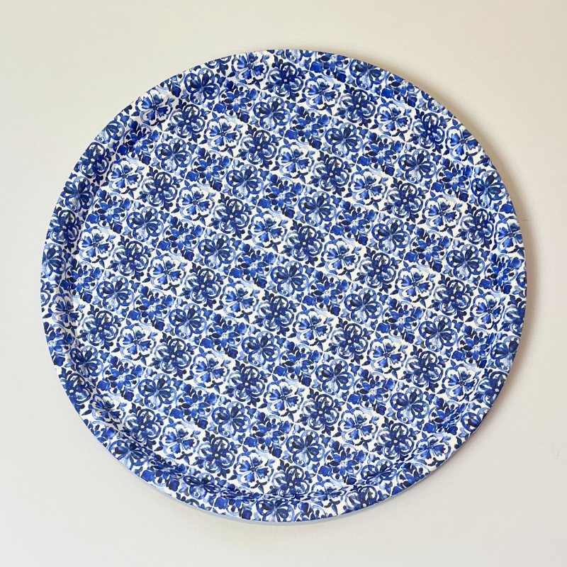 Round blue floral patterned plate on a beige background