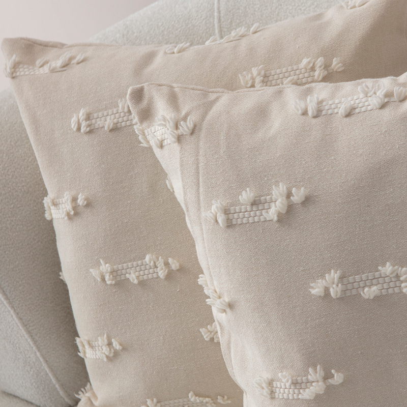 Beige textured woven throw pillow on light sofa – decorative cushion with woven tufted details