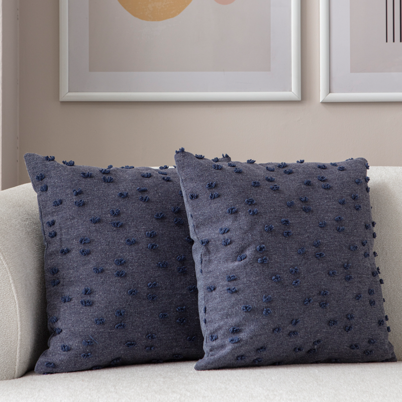 Navy blue tufted throw pillow on light sofa – textured decorative cushion