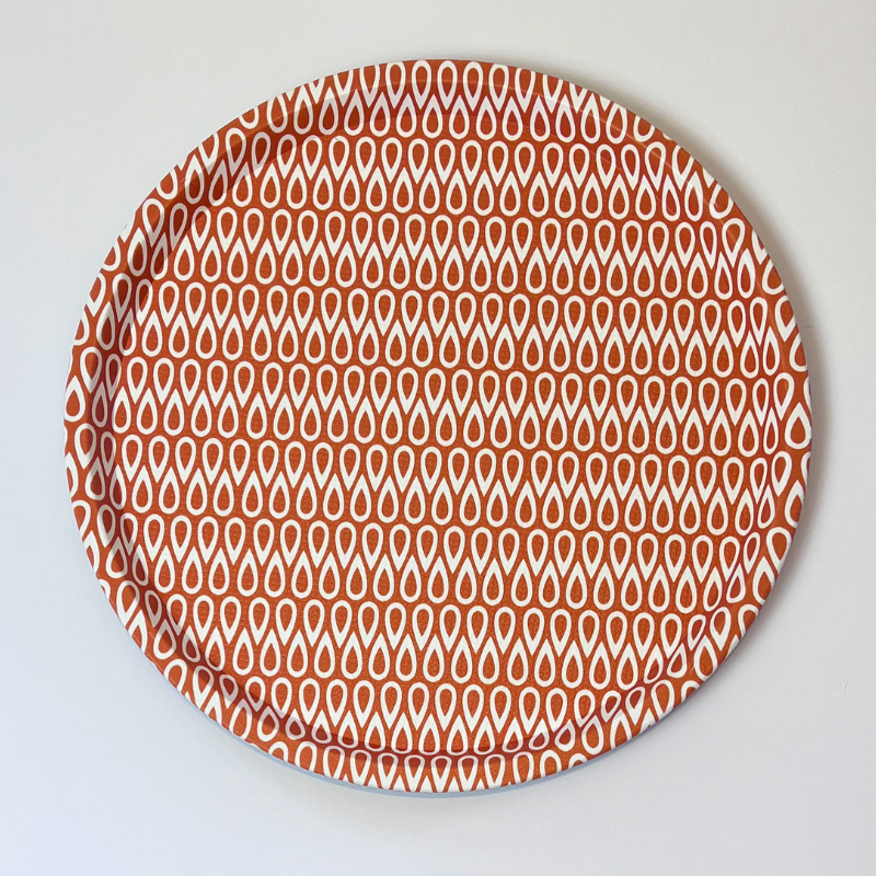 Round plate with a red and white pattern on a light gray background