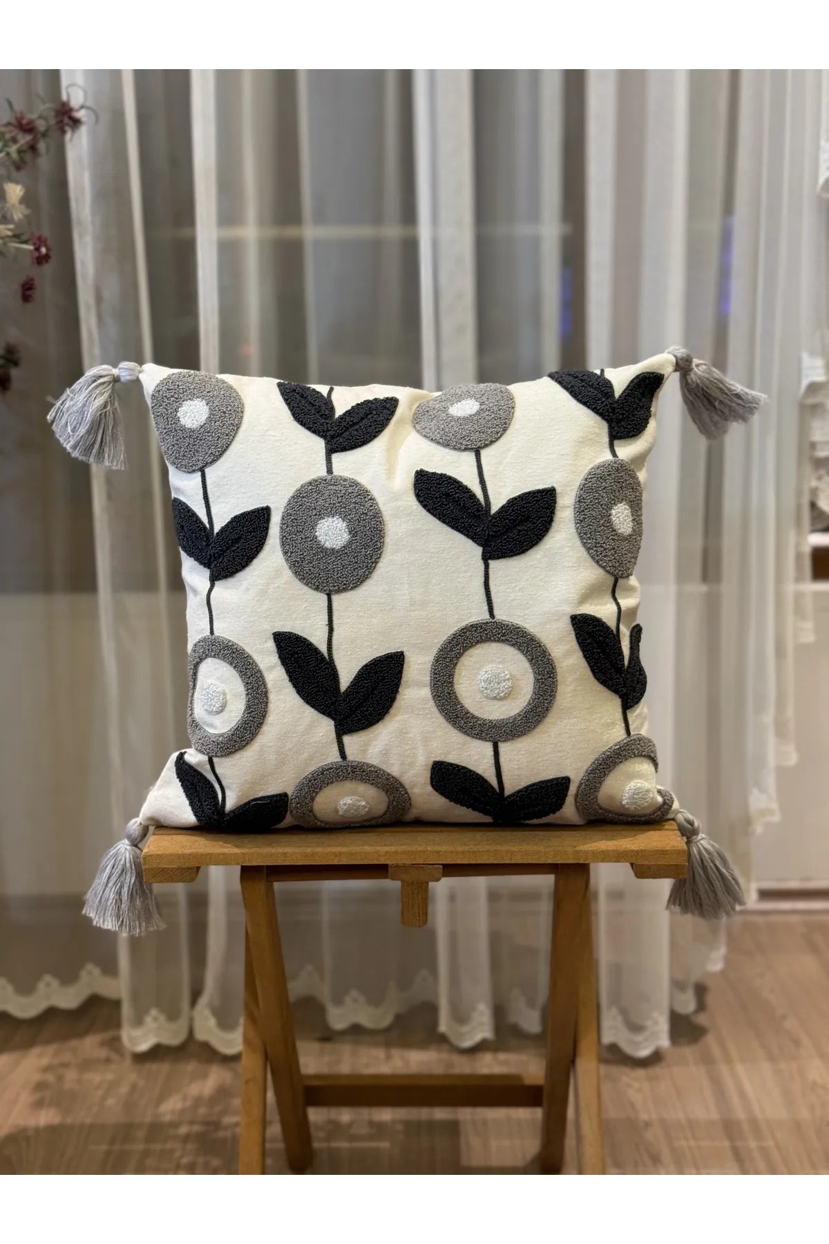 Nordic Bloom cushion cover with navy and grey floral embroidery and tassels