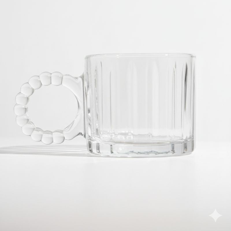 Clear ribbed glass mug with beaded handle on white background
Vintage-style glass coffee cup with decorative handle
Transparent ribbed mug for coffee, tea, or juice
Artistic clear glass mug with round beaded handle