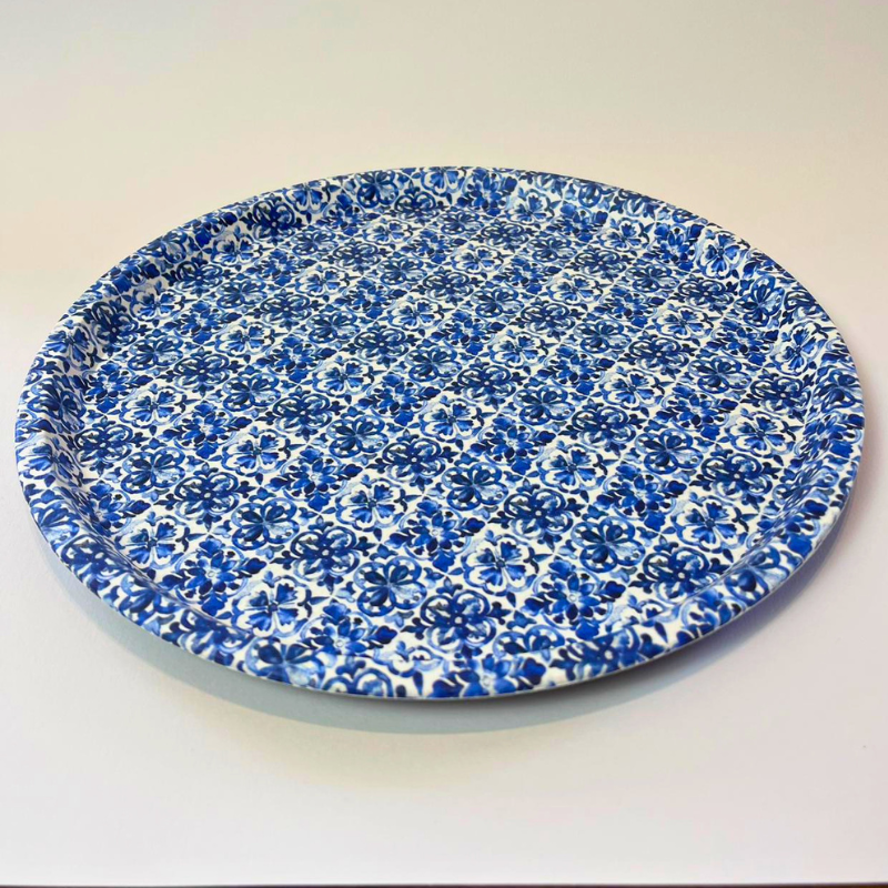 Round blue and white floral-patterned plate on a light background