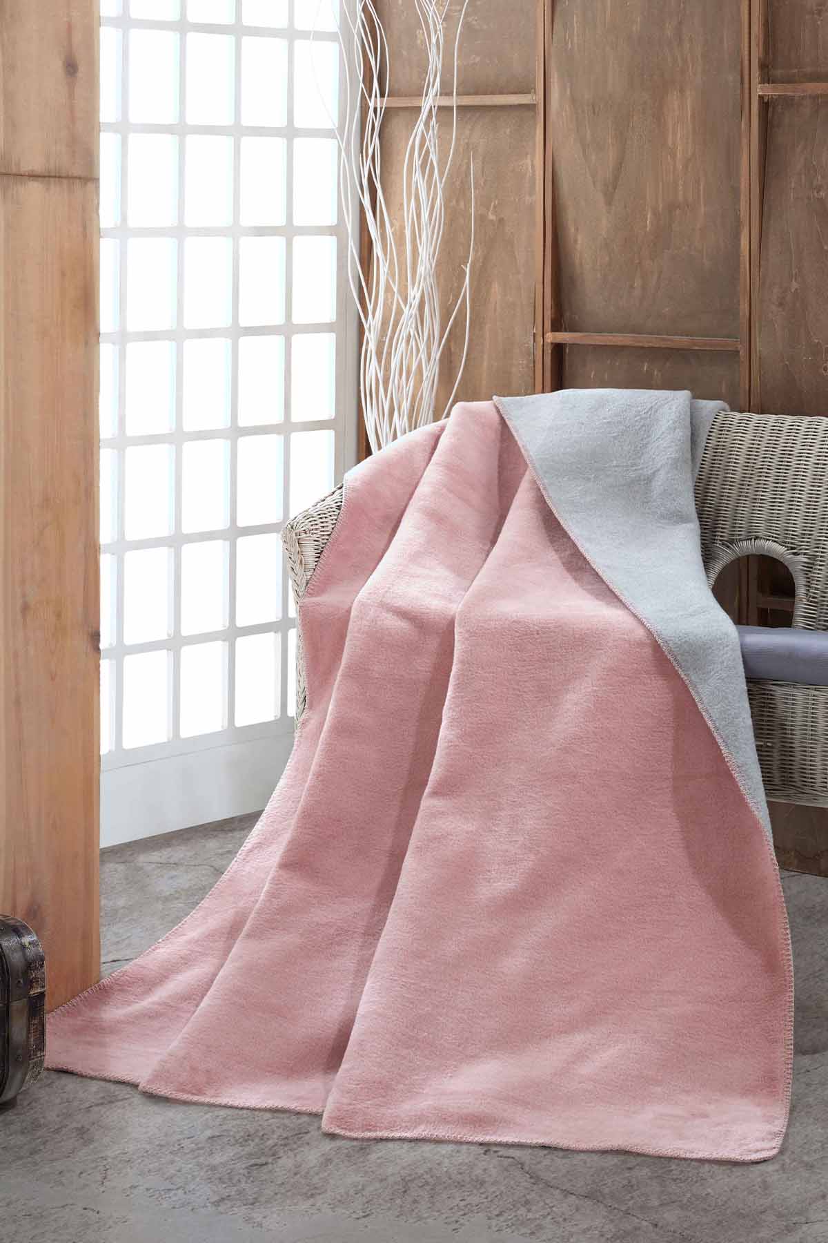 Double-face fleece blanket in pink and grey draped on chair
