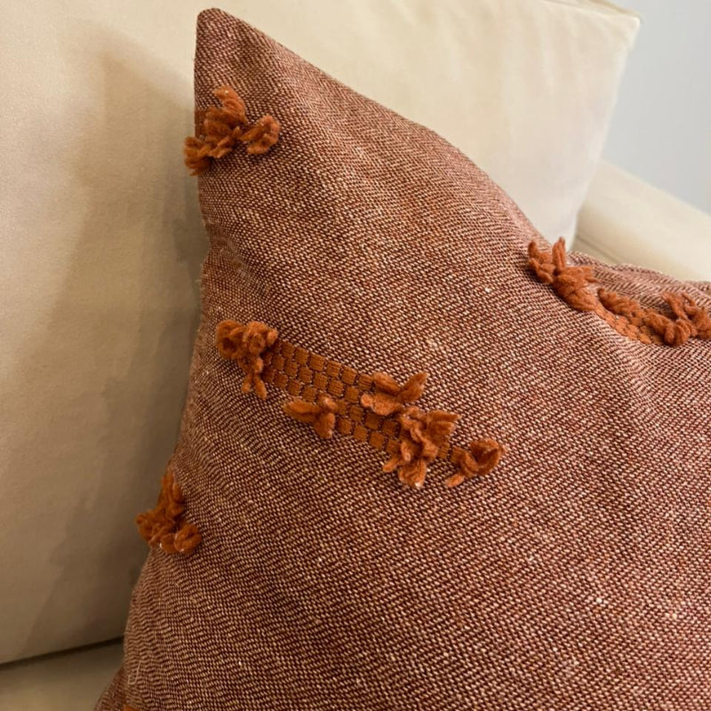 Terracotta textured fringe decorative cushion cover with woven fabric on beige sofa