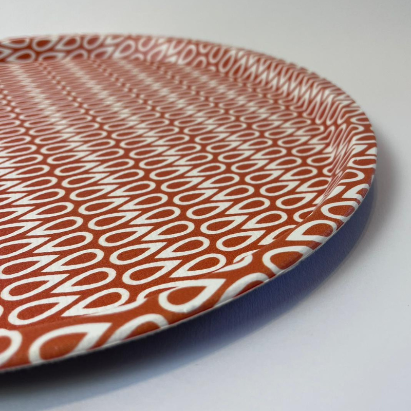 Round plate with a red and white pattern on a light gray background