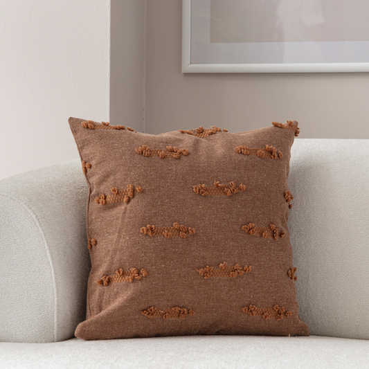 Warm brown woven textured throw pillow on light sofa – decorative cushion with horizontal tufted accents