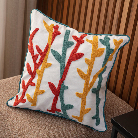 Cream cushion cover with colorful tufted abstract botanical embroidery in teal, mustard, and red