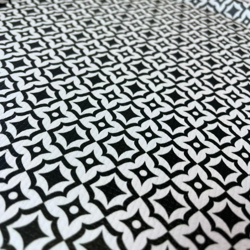 Round ceramic plate with black geometric pattern on a white background