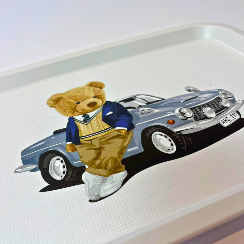Tray with a teddy bear and car illustration on a white background