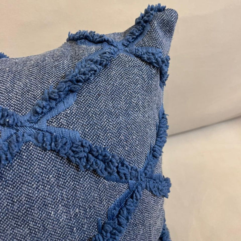 Dusty blue textured decorative cushion cover with raised diamond pattern on beige sofa