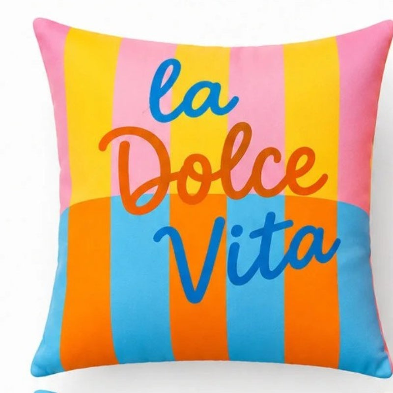 Set of four colorful Mediterranean-inspired decorative cushion covers featuring "La Dolce Vita" typography, floral ceramic planters, striped backgrounds, and a vibrant rainbow wave pattern displayed on a modern cream sofa.