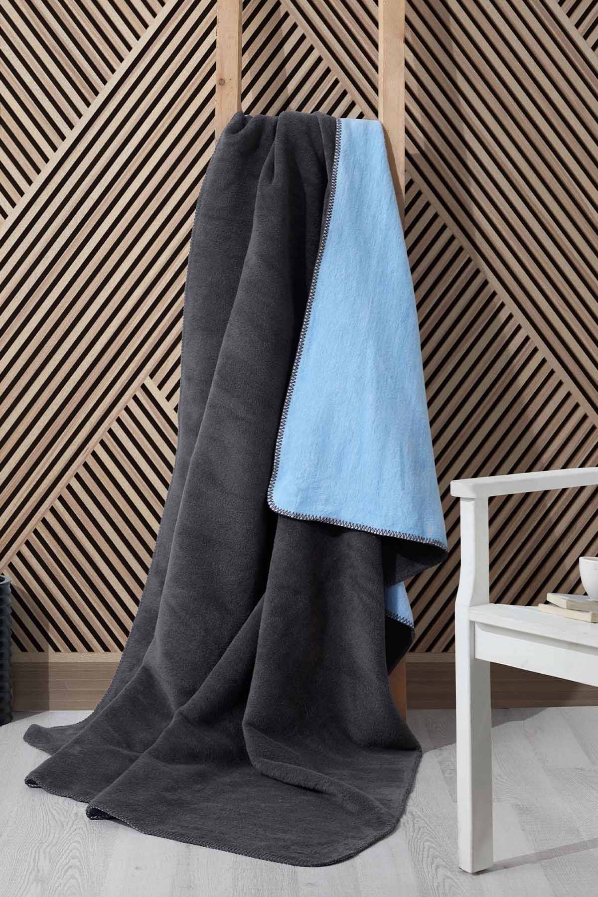 Double-face fleece blanket in pink and grey draped on chair