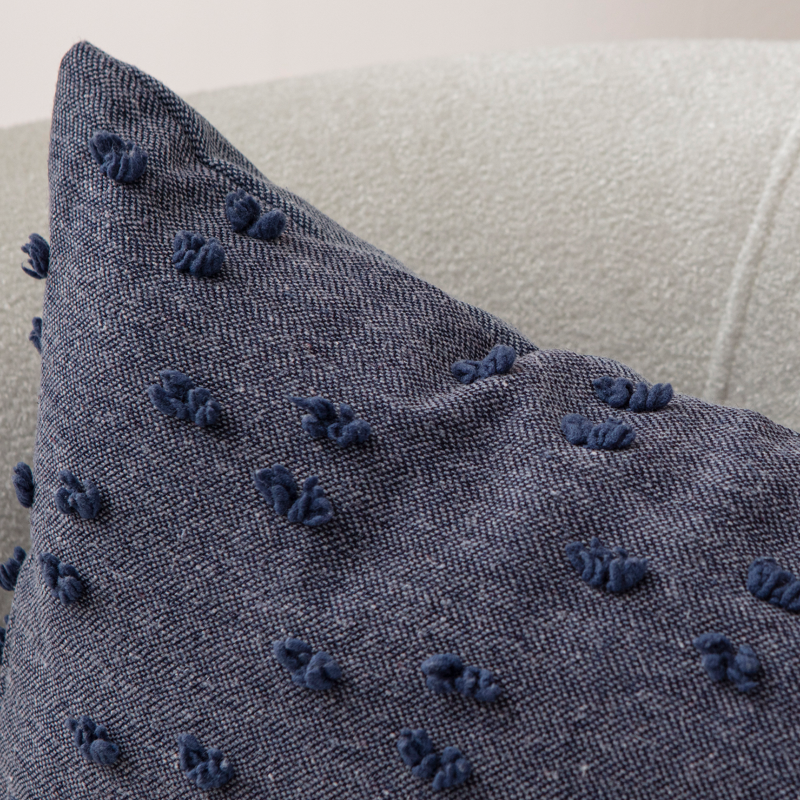Navy blue tufted throw pillow on light sofa – textured decorative cushion