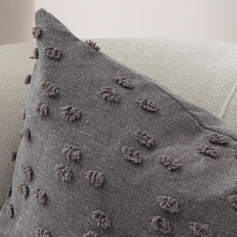 Charcoal textured tufted throw pillow on light sofa – modern decorative cushion